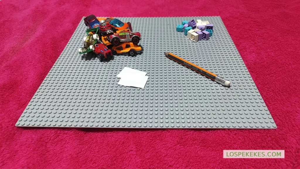 Materiales necesarios para la actividad: base de LEGO, carros de juguete, bloques, papel, lapiz.